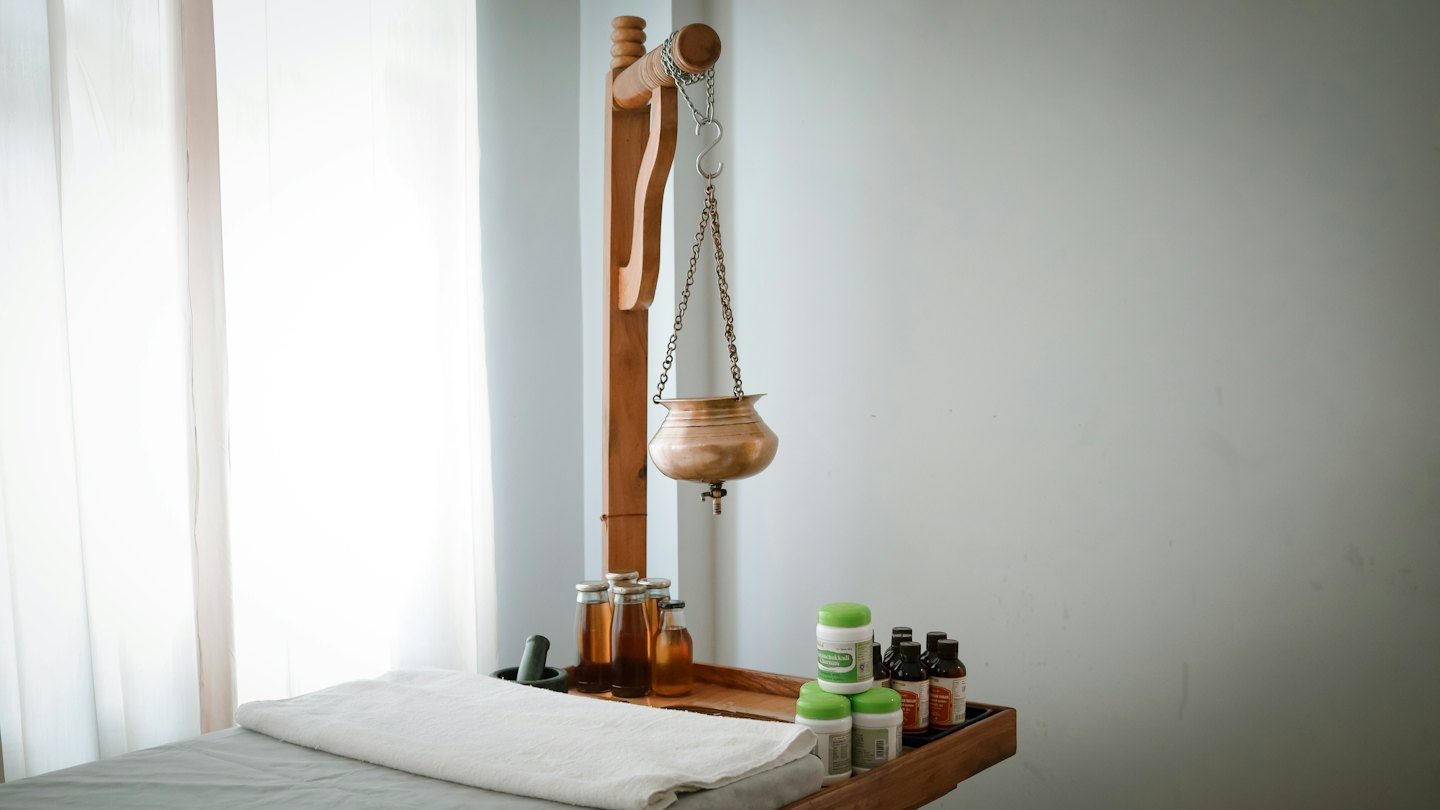 En Shirodhara-kruka hänger över ett massagebord på ett spa.